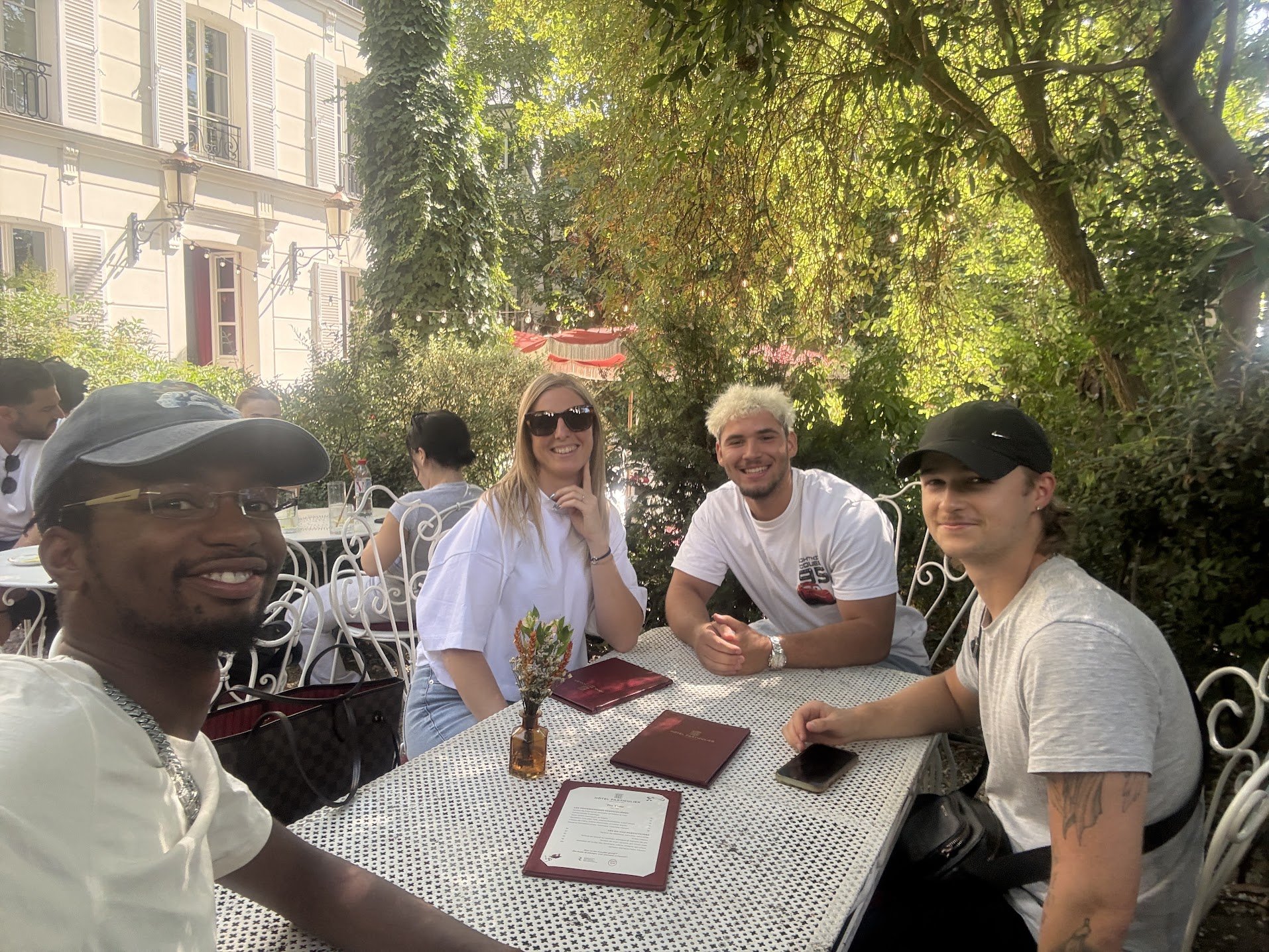Le Pot de Traders de juillet 2026, quatre membres de la communauté attablés à la terrasse d'une adresse parisienne