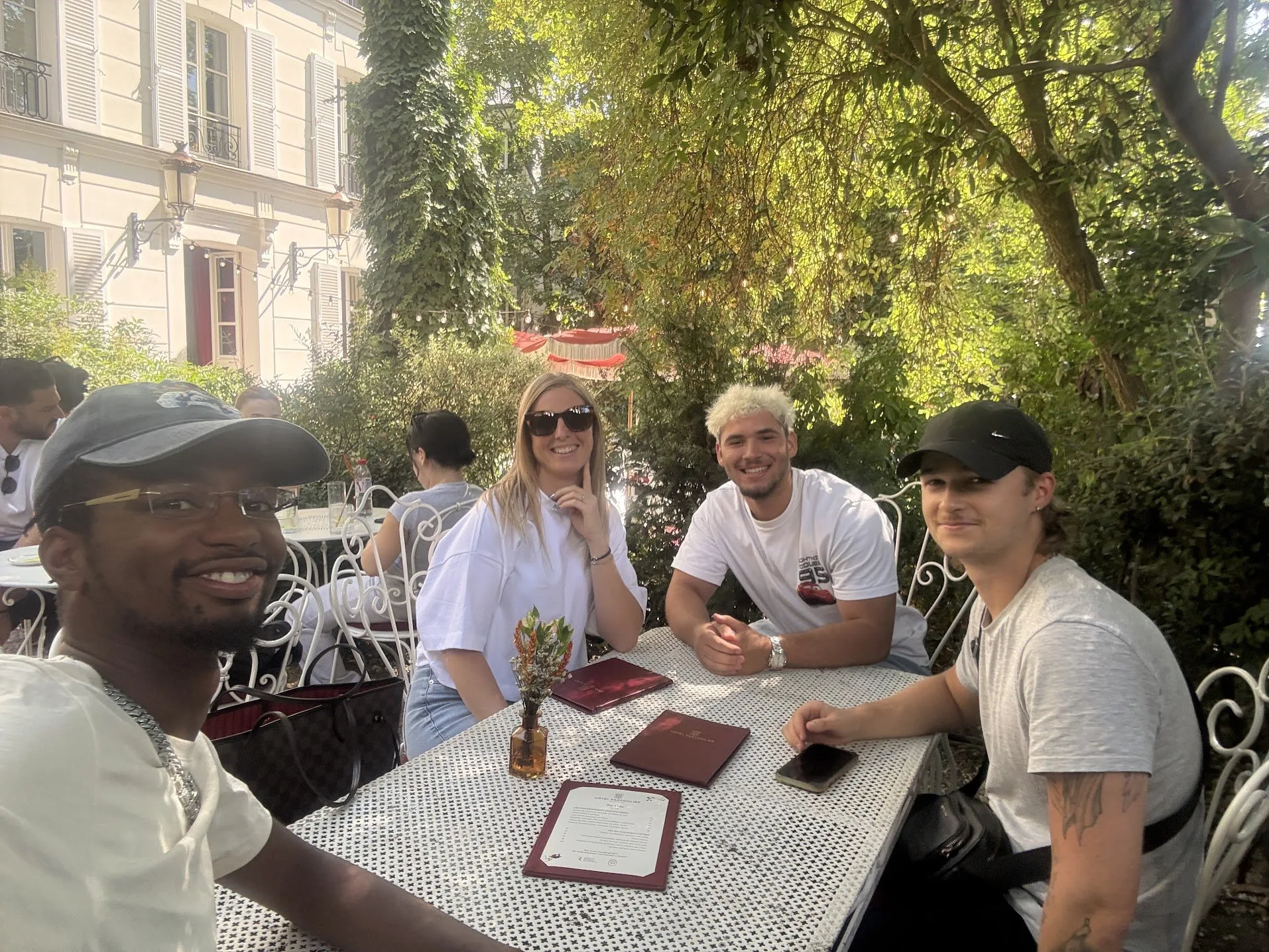 Le Pot de Traders de juillet 2026, quatre membres de la communauté attablés à la terrasse d'une adresse parisienne